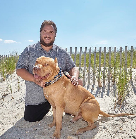 Evan Metropoulos with dog seated oppo